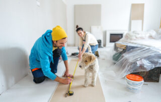 Couple is renovating their home with new walls and flooring with dog
